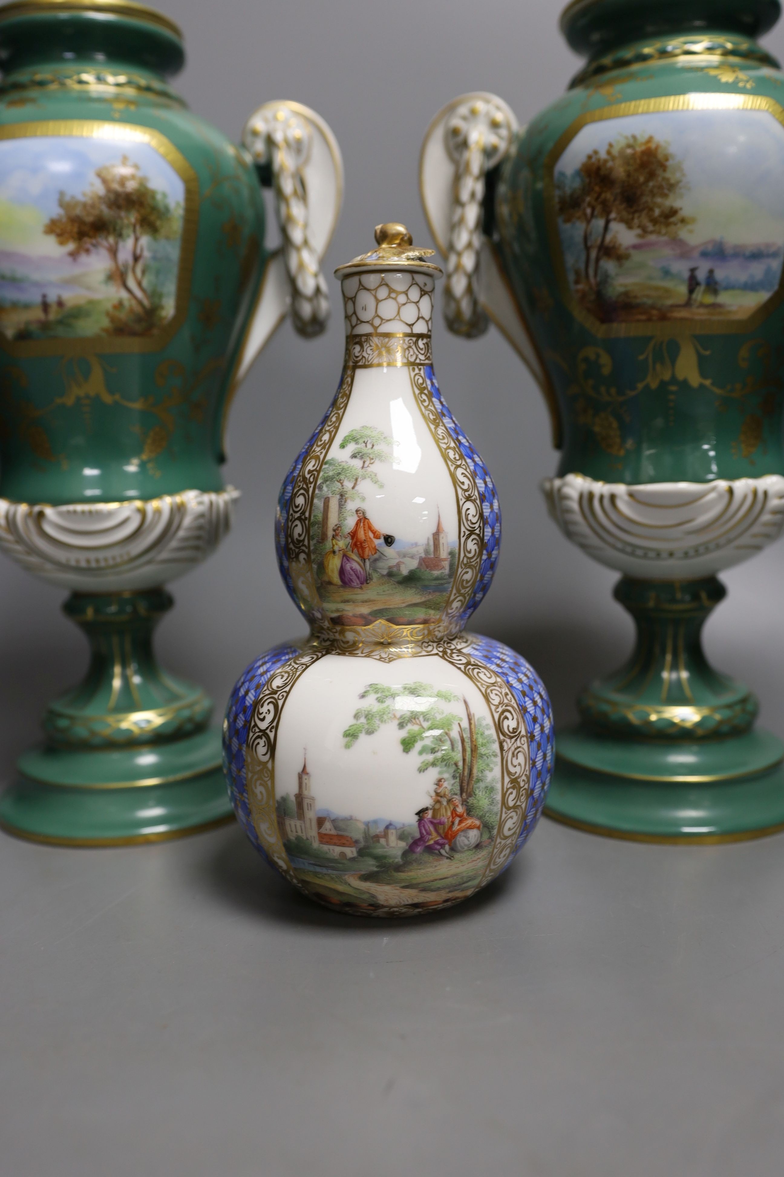 A pair of early 20th century Dresden vases painted with landscapes on an avocado green ground, 24cm high together with a German bottle vase and cover painted with four landscape panels separated by blue and white panels